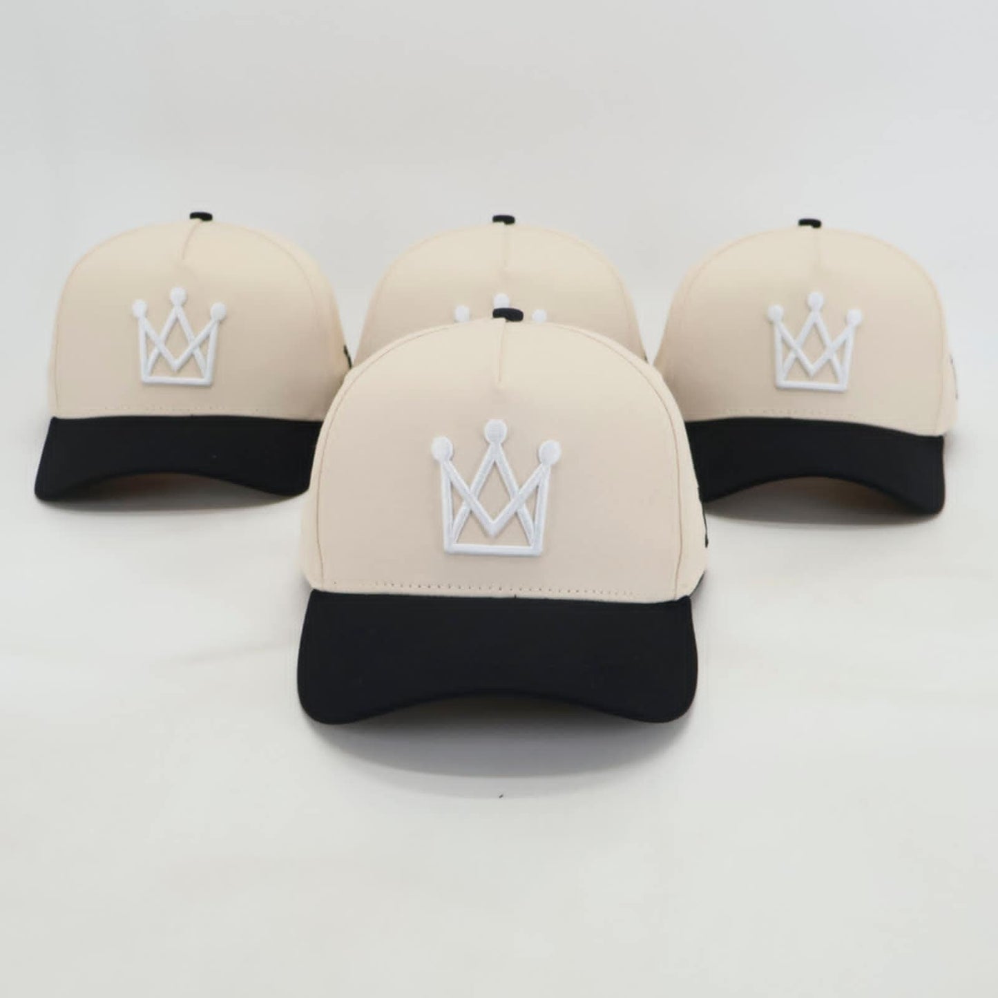 Beige and black snapback hat with white crown logo - front view